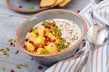 Tasty and healthy oatmeal porridge with mango, pomegranate and seeds. Healthy breakfast. Fitness food. Proper nutrition.
