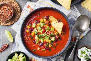 Mexican tomato, bean, bell pepper soup in bowl.