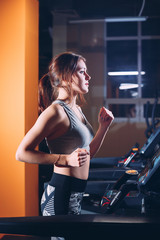 Fototapeta na wymiar the girl on the treadmill in the gym