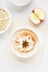 Oats porridge with red apple slices and cinnamon