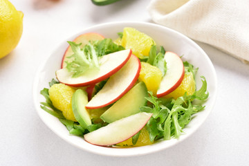 Fruit salad with red apples, avocado, orange slices