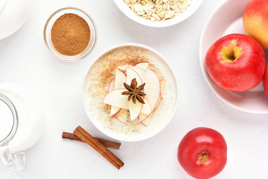Oatmeal porridge with red apple slices and cinnamon