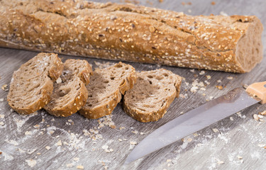 slices of wheaten bread and knife on wooden surface