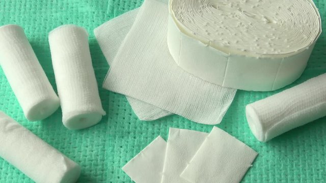 White medical cotton gauze bandage on green background