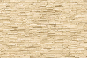 Rock stone brick tile wall aged texture detailed pattern background in cream beige brown color