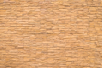 Rock stone brick tile wall aged texture detailed pattern background in cream beige brown color