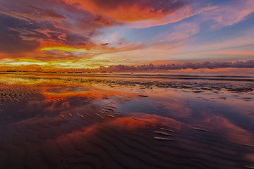 vibrant sunset and beautiful clouds with reflection. image contain soft focus due to long expose.