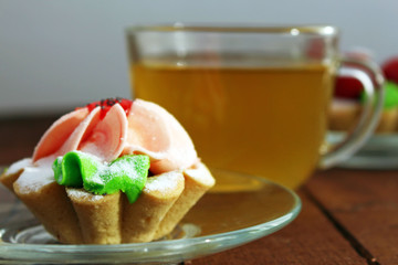 bright cakes in the form of baskets on the background of a wooden table with tea