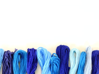 close up group of colorful spools of sewing thread top view on white background