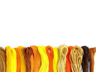 close up group of colorful spools of sewing thread top view on white background