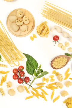 Overhead photo of different types of pasta on white, forming frame
