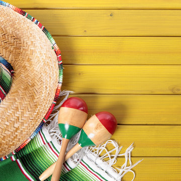 Cinco de mayo mexican background border with mexico sombrero straw hat blanket rug and maracas on old pine wood fiesta festival photo square format
