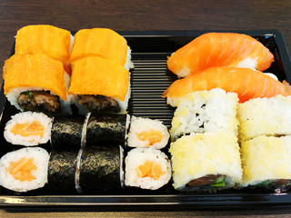 Sushi rolls holding by chopsticks. A traditional dish of Japanese cuisine