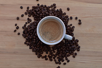 Coffee cup and coffee beans on wooden background. Top view.