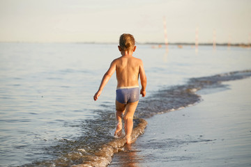 water fun. the boy runs along the seashore