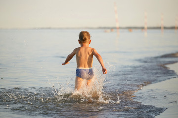 water fun. the boy runs along the seashore