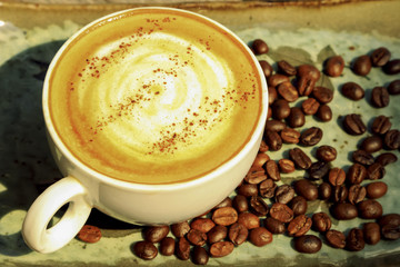 Hot coffee cappuccino in white cup decorated on wooden background.