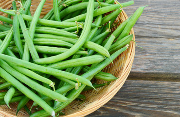 Green beans in the basket on wooden background