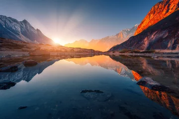 Photo sur Plexiglas Himalaya Beau paysage avec de hautes montagnes avec des pics illuminés, des pierres dans un lac de montagne, un reflet, un ciel bleu et une lumière du soleil jaune au lever du soleil. Népal. Scène incroyable avec les montagnes de l& 39 Himalaya. Himalaya
