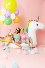 Summer Fashion Girls Having Fun With Balloons On Unicorn Float