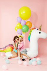 Obraz na płótnie Canvas Summer Fashion Girls Having Fun With Balloons On Unicorn Float