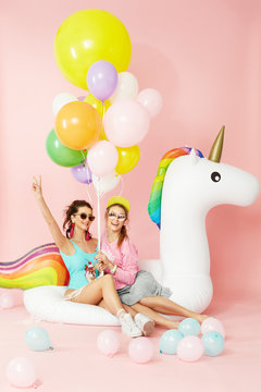 Summer Fashion Girls Having Fun With Balloons On Unicorn Float