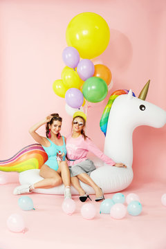 Summer Fashion Girls Having Fun With Balloons On Unicorn Float