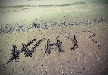 WHY written on the sand with vintage effect