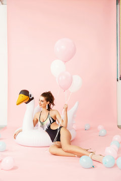 Summer Style. Woman In Swimsuit With Balloons And Pool Floats