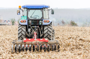 Fototapeta premium Modern tractor is working in the field