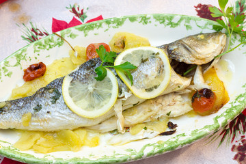 Sea bass baked with potatoes and tomatoes