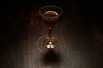 glass of drink - crystal cup on dark aged wooden desk