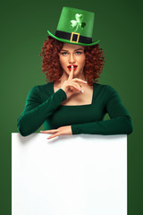 St Patrick Day. Young sexy oktoberfest woman, wearing a dress and green hat with white banner for copy space