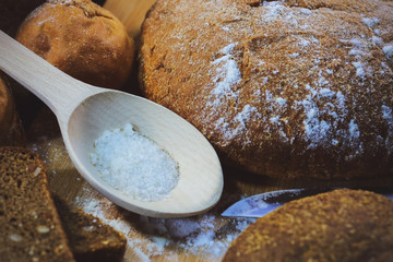 brown bread. cut bread. salt. on a wooden table.
