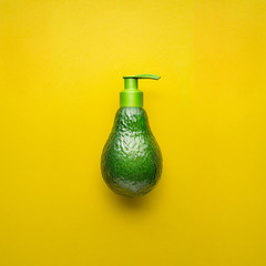 Natural beauty / Creative concept photo of avocado with cream dispenser on yellow background. © Fisher Photostudio