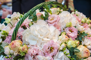Roses of pink modern varieties with hydrangea and flowers in a bouquet in a wicker basket as a gift. Background. Shut. Selective focus. Close Up.
