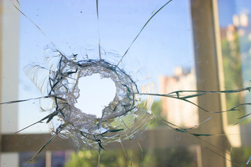 broken glass window reflecting blue sky