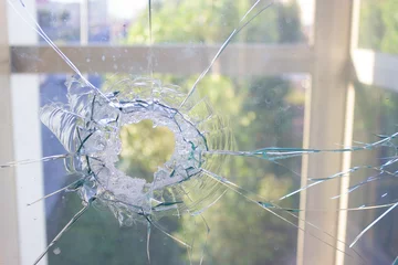 broken glass window reflecting blue sky © lijphoto