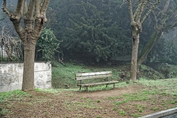 Fototapeta premium Alone benche in the foggy towpath, no people, lonely mood