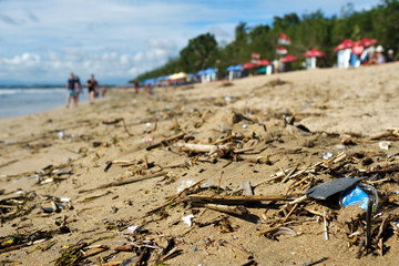 Fototapeta na wymiar Beach pollution in Bali Indonesia. Plastic rubbish and other trash on sea beach. Ecological disaster in Indonesia