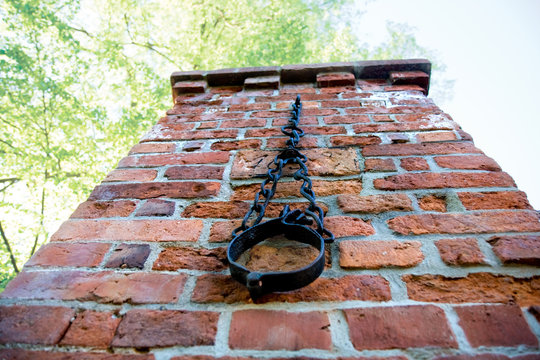 eiserner Pranger an einem alten Backstein-Tor