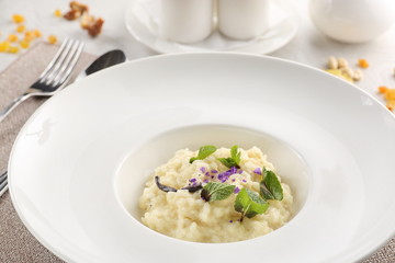 rice porridge in a white plate on a white wooden background