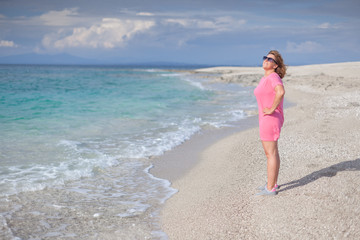 Cheerful woman having fun enjoying the sun at idyllic beach
