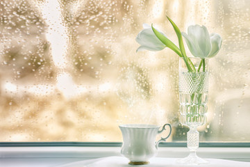 bouquet of tulips on a windowsill on a rainy day
