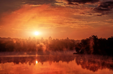 wonderful misty morning. majestic red sunrise over the foggy lake