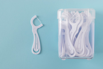 A box of white dental flossers on bright blue background.