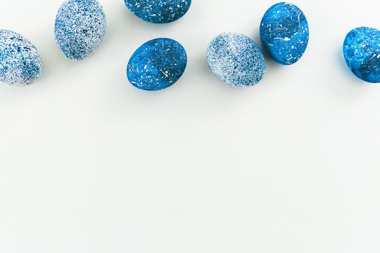 Easter composition. Border frame of Blue Easter eggs on white background. Flat lay. Top view