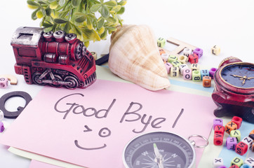 GOOD BYE word written by hand and decoration items on white desk