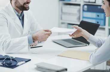 Doctor giving a prescription to a patient
