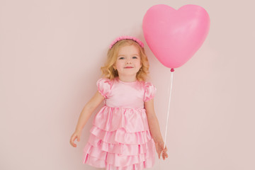 Obraz na płótnie Canvas Happy cute little girl with pink balloon heart on a pink background. mother's day, birthday